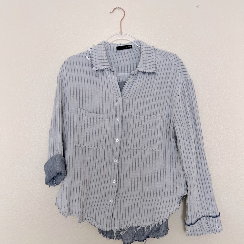 On blue, blue and white button up women’s top.